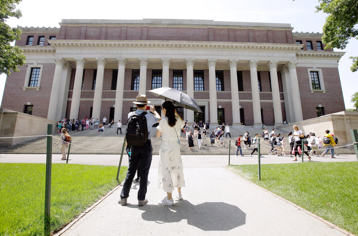 FILE - In this July 16, 2019, file photo, people stop to record images of Widener Library on the campus of Harvard University in Cambridge, Mass. U.S. District Judge Allison D. Burroughs ruled, Tuesday, Oct. 1, 2019, that Harvard does not discriminate against Asian Americans in its admissions process. The judge issued the ruling in a 2014 lawsuit that alleged Harvard holds Asian American applicants to a higher standard than students of other races. Burroughs said Harvard's admissions process is not perfect but passes constitutional muster. (AP Photo/Steven Senne, File)